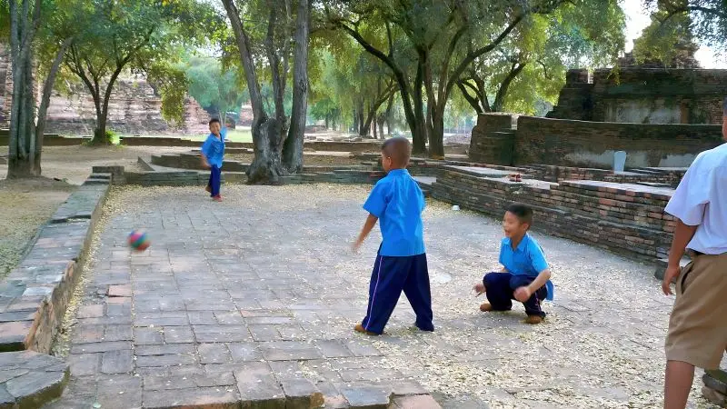 一群泰國小朋友在寺廟前踢足球