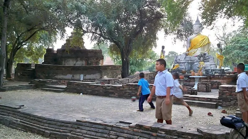 一群泰國小朋友在寺廟前踢足球