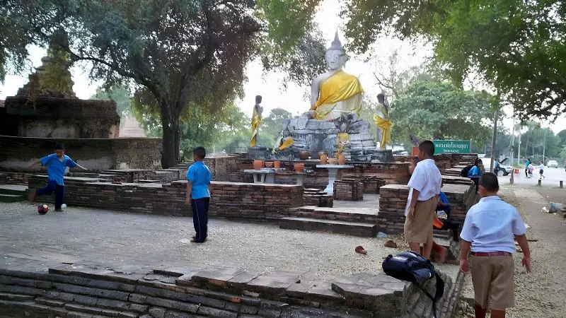 一群泰國小朋友在寺廟前踢足球