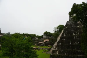 a stone pyramids with trees and buildings in the background