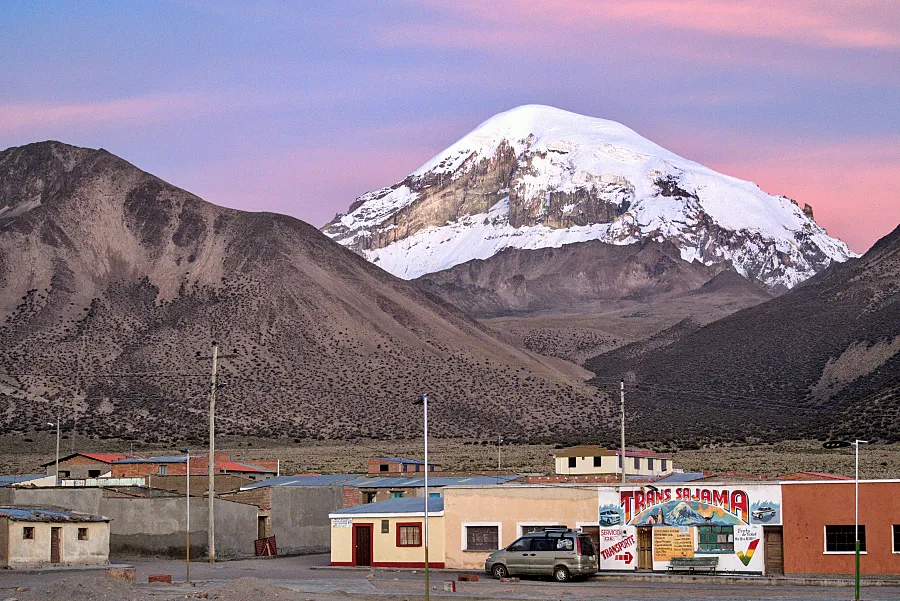 薩哈馬火山像一位穿著白色斗篷的老者在夕陽的粉紫色的天空下面俯瞰著這個村莊。